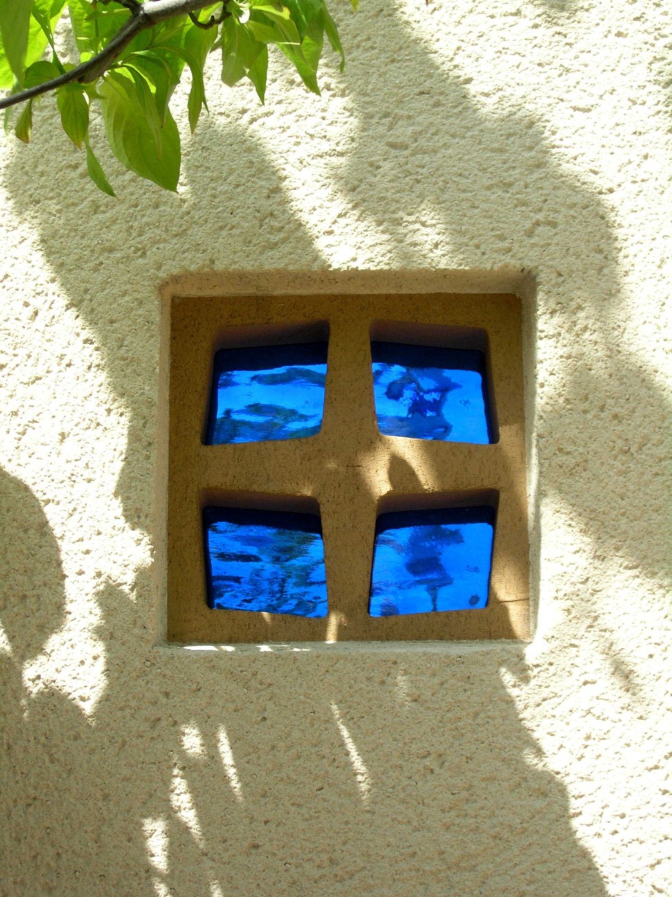 白壁とウッドデッキ、そしてブルーガラスの穴あきブロック